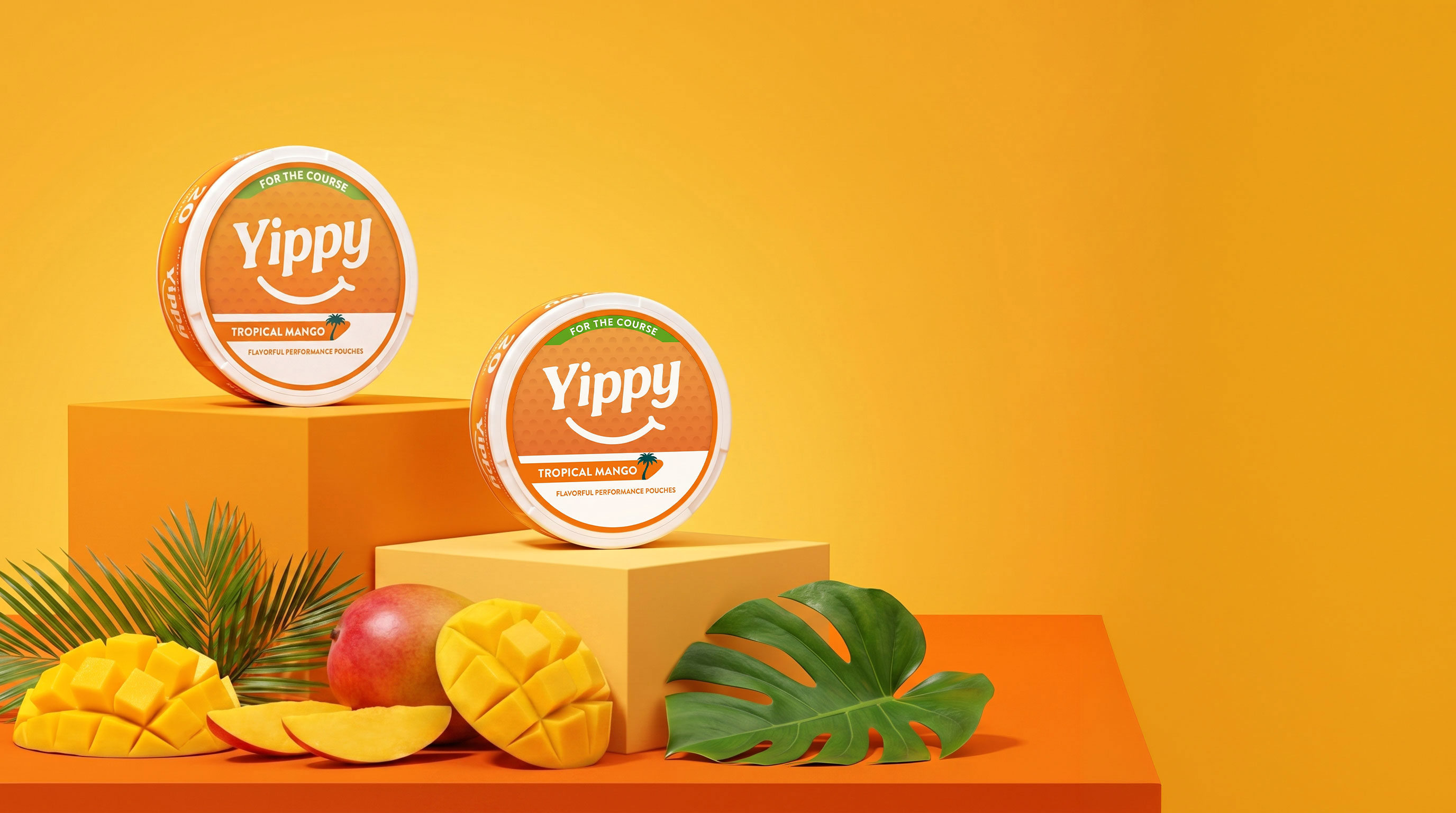 Yippy Tropical Mango pouches on orange podiums with fresh mango, peach, and monstera leaves in a sunlit tropical studio set